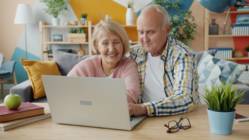 An older couple looking at a laptop together at home